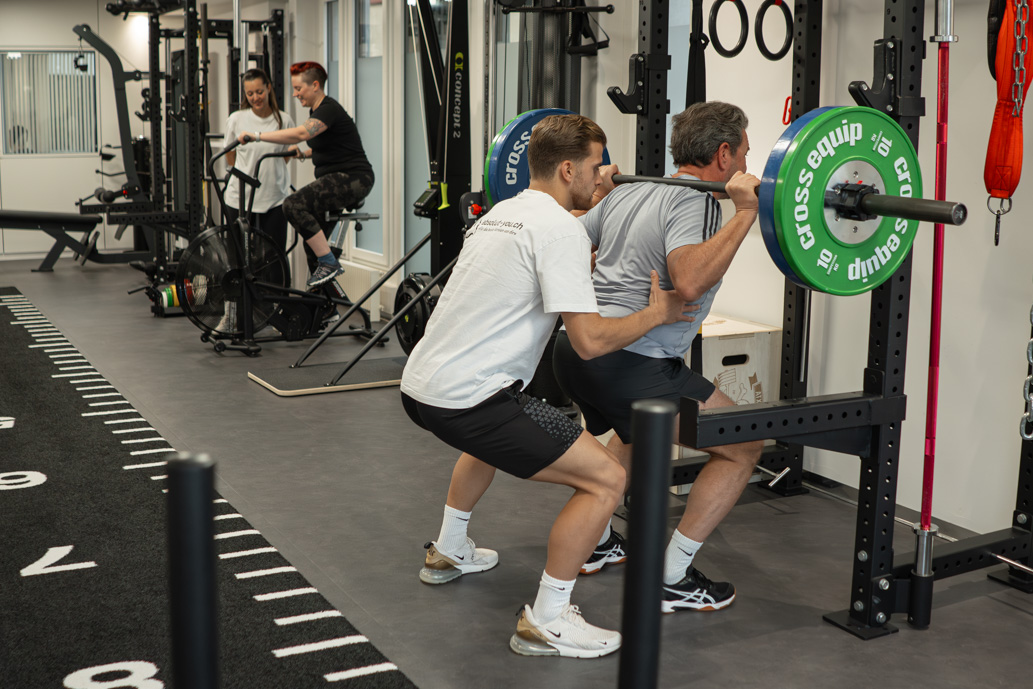 Urs bei der Langhantel Kniebeuge mit Gian-Marco als Spotter – Maximale Sicherheit und Unterstützung im Training bei Absolut You.