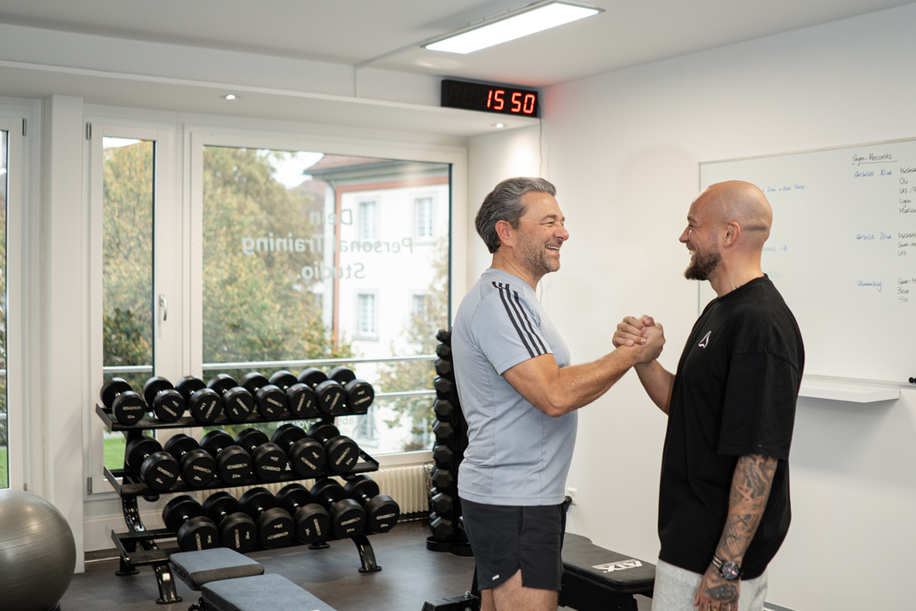 Florian Kamm und Urs beim Händeschütteln nach einem erfolgreichen Training – Erfolg durch Personal Coaching bei Absolut You.